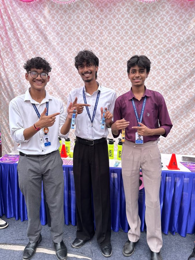 Three students posing at the RAYY stall