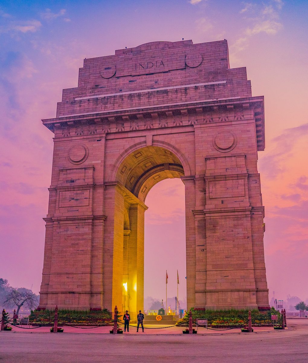 India Gate in New Delhi at dawn under a pink and purple sky